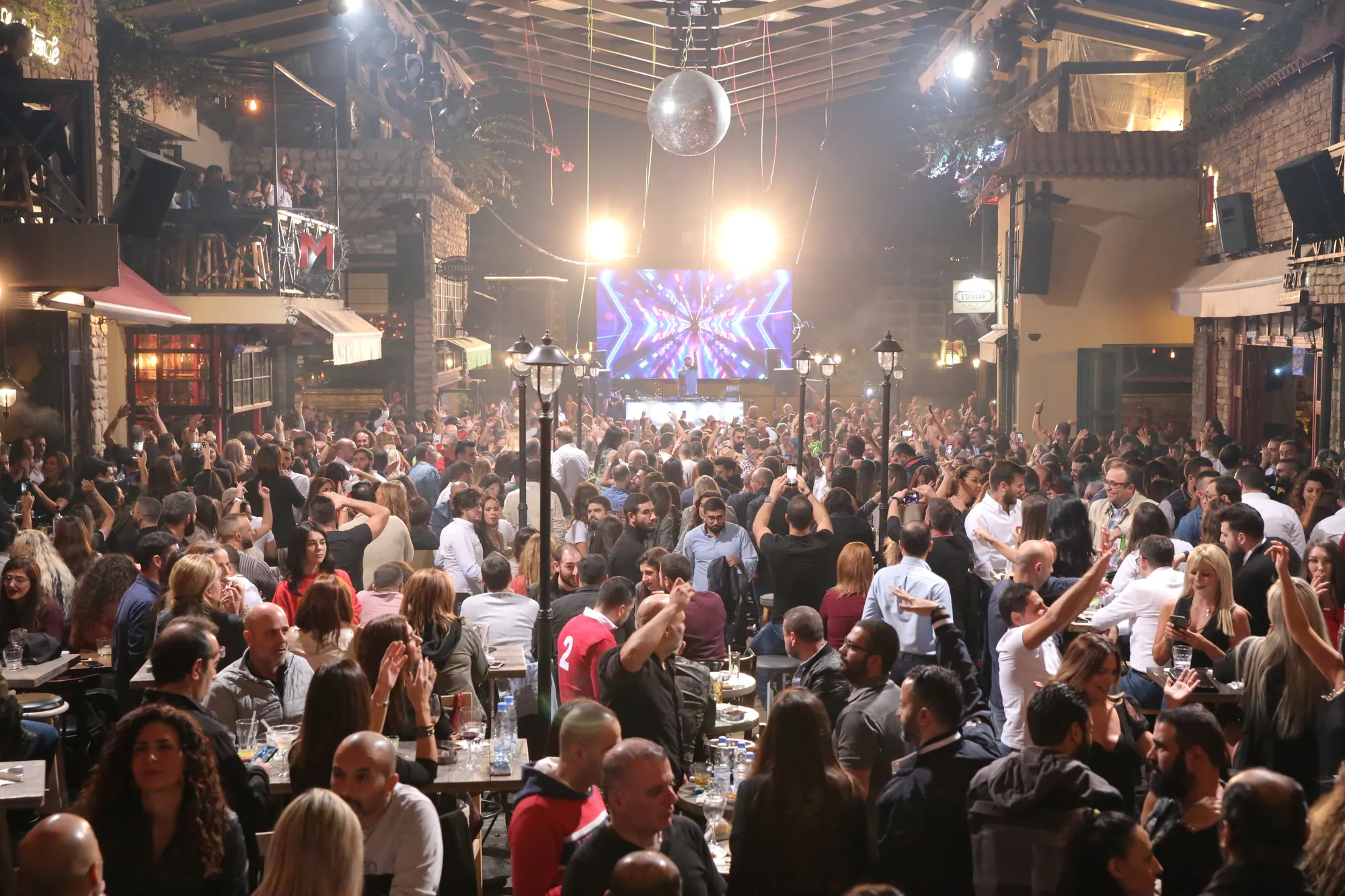 Guests filling an indoor venue in front of a lit stage